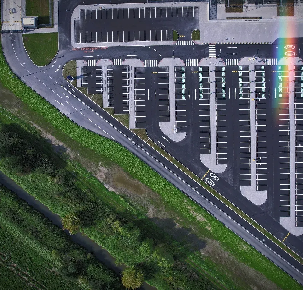 Aerial view of a developed plot beside a river and fields